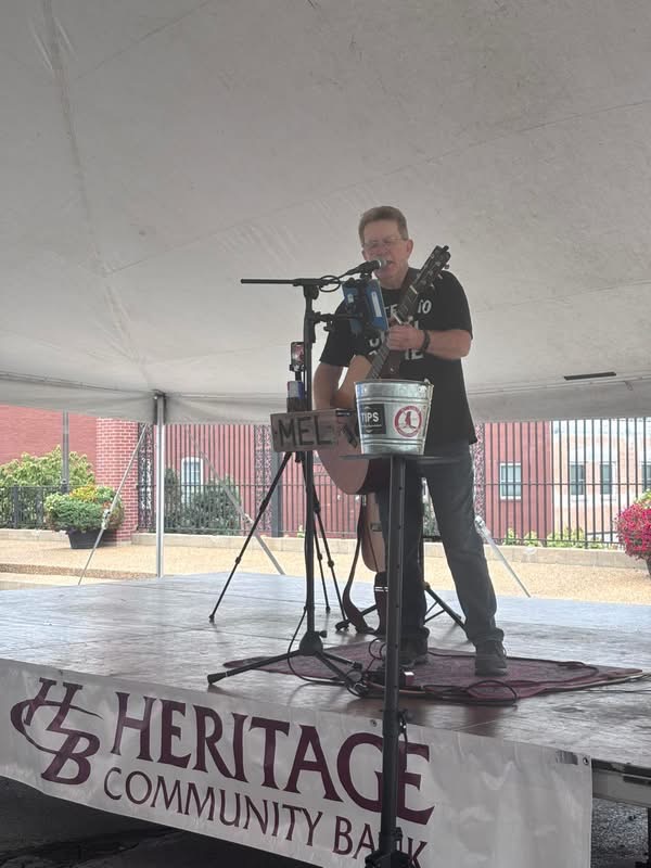 Mel Hughes performing on a festival tent stage